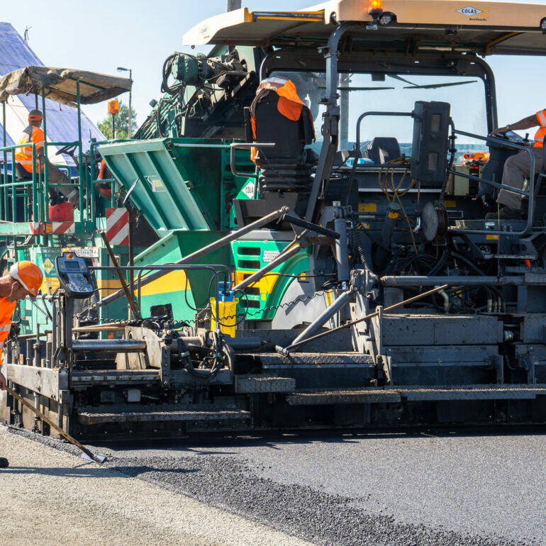 Machine BTP posant du bitume