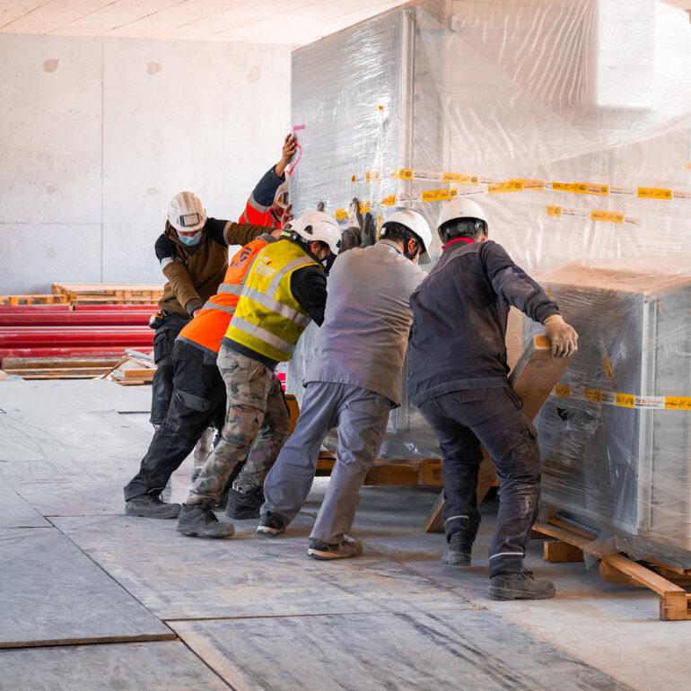 Ouvrier déplaçant des palettes de chantier