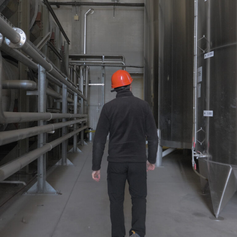 Vidéo Corporate - homme marchant entre les cuves